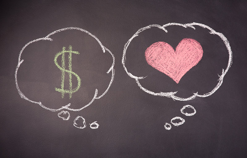 Dessin au tableau noir contenant deux bulles de dialogue dessinées à la craie, l'une contenant un symbole d'argent et l'autre un cœur.