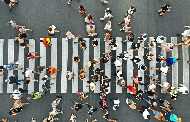 Aerial view showing crowd of people walking on a crosswalk.