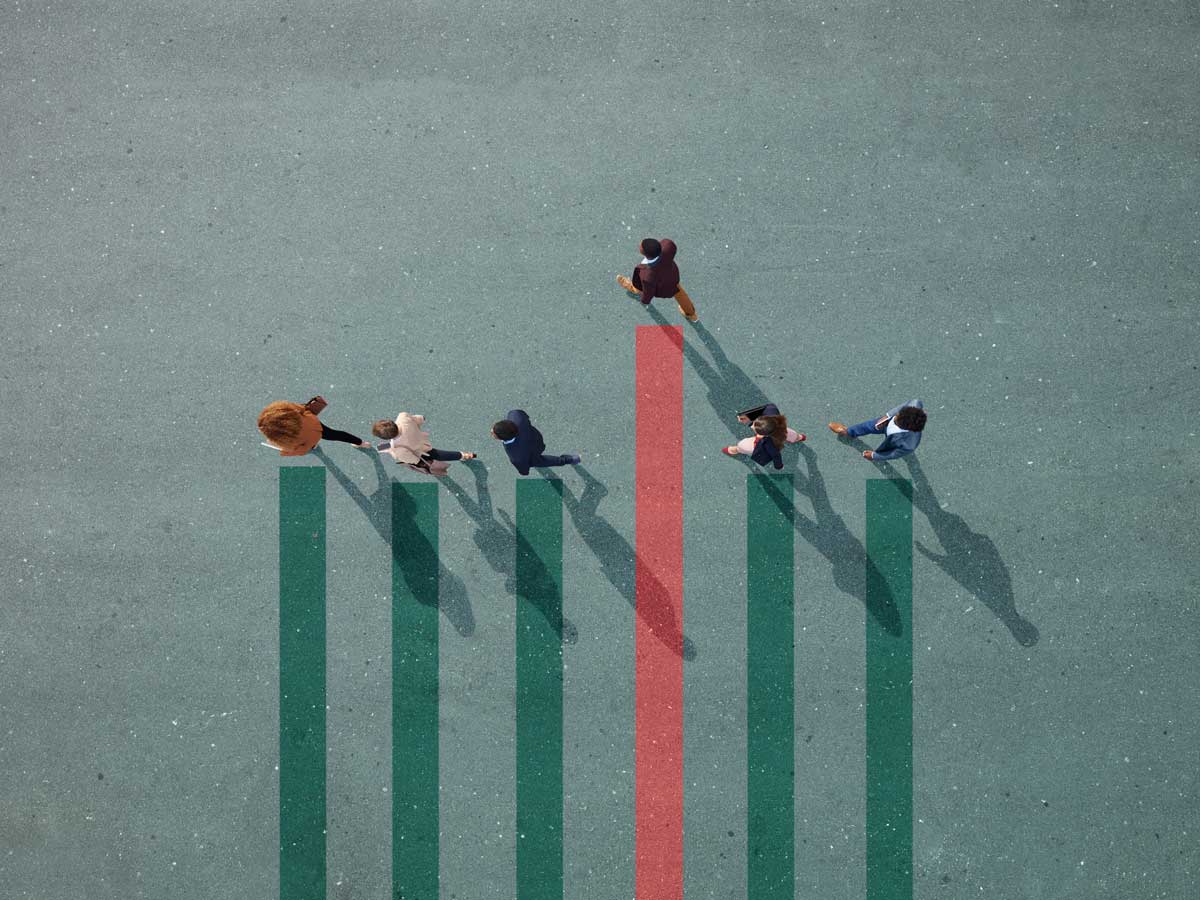 Hommes d'affaires marchant en ligne sur un graphique à barres peint sur asphalte, une personne est plus haute sur le graphique que les autres