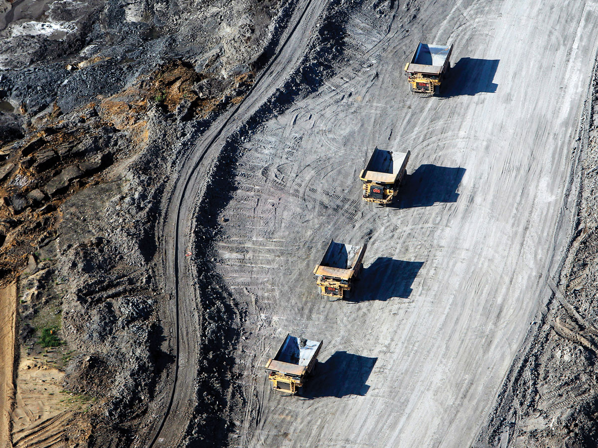 An overhead show of massive dump trucks at a mining site