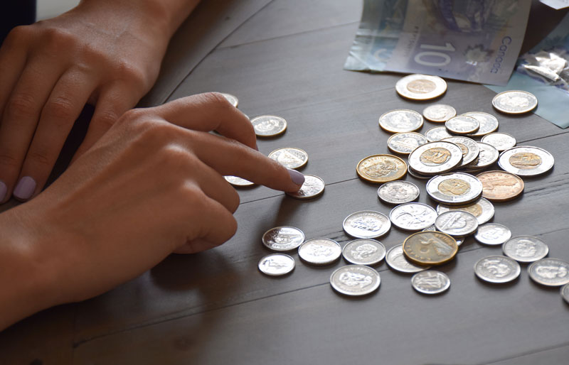 Close up of person counting coins.