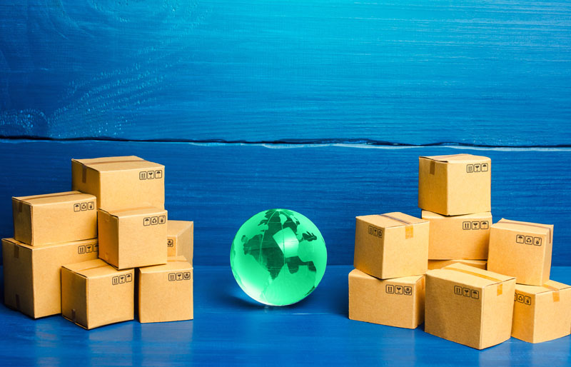 Shipping boxes and glass globe on blue background.