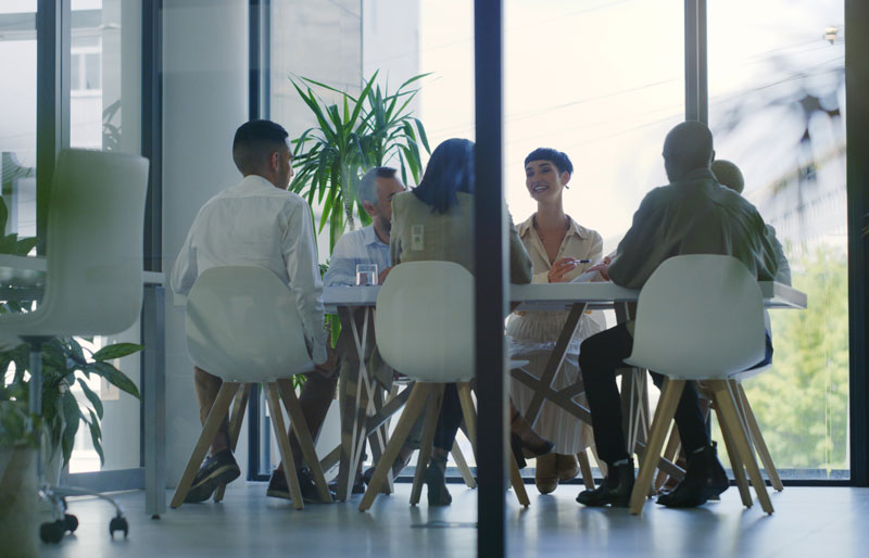 Group of business people sitting around a table in an office.